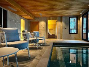 a living room with a swimming pool and chairs at Appartement neuf avec terrasse, SPA et parking inclus - 6 pers - FR-1-352-103 in Arc 1800