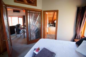 a bedroom with a bed and a living room at Kauri House Apartment in Wanaka