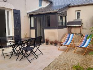 a patio with chairs and a table and a house at Escapade nature et patrimoine, près de la Loire - FR-1-590-443 in Tavers