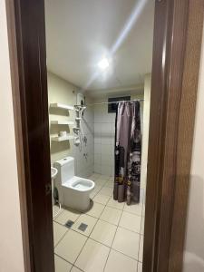 a bathroom with a toilet and a shower at Jojies Crib Horizons101 2bedrooms in Cebu City