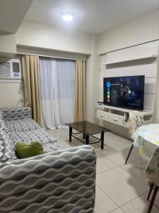 a living room with a couch and a flat screen tv at Jojies Crib Horizons101 2bedrooms in Cebu City