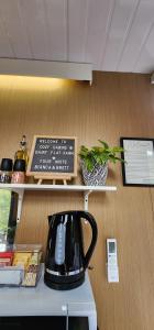 a coffee maker sitting on a shelf in a room at Cozy Cabin2 with outdoor Bath at Dairy Flat Farm in Waitoki