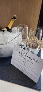a table with two wine glasses and a bottle of champagne at Cozy Cabin2 with outdoor Bath at Dairy Flat Farm in Waitoki