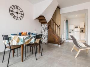 a dining room with a table and chairs and a clock at Maison rénovée avec wifi, centre bourg de St Mars la Jaille - FR-1-306-1289 in Vallons-de-l'Erdre