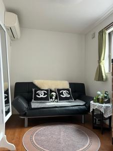 a black leather couch in a living room at 5LDK3toilets: 最近の駅6分・スカイツリー電車1分・浅草電車4分・NRT電車60分 in Tokyo