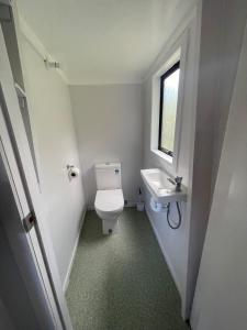 a small bathroom with a toilet and a sink at Pukenui Holiday Park in Pukenui +29 photos