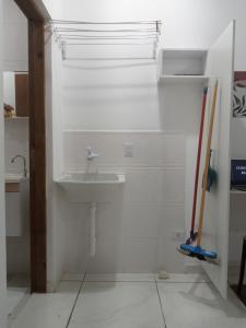 a white bathroom with a sink and a counter at LOFT 2 COMPLETO AR CANAIS ASSINAT GARAGEM INTERNET prox Aparecida e Industrias in Pindamonhangaba +27 photos