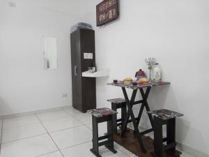 a kitchen with a table and stools and a refrigerator at LOFT 2 COMPLETO AR CANAIS ASSINAT GARAGEM INTERNET prox Aparecida e Industrias in Pindamonhangaba