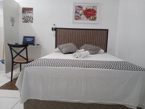 a bedroom with a large bed with a wooden headboard at LOFT 2 COMPLETO AR CANAIS ASSINAT GARAGEM INTERNET prox Aparecida e Industrias in Pindamonhangaba