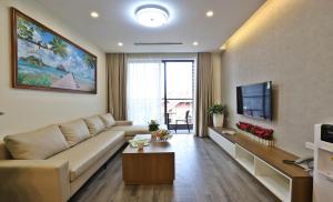 Una sala de estar con un sofá y un televisor. en BEU Home Tay Ho, en Hanói