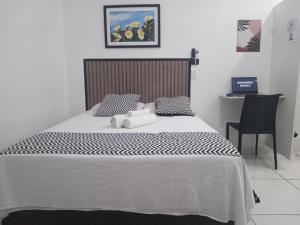 a bedroom with a bed with two towels on it at LOFT3 COMPLETO AR CANAIS ASSINAT GARAGEM INTERNET Prox Aparecida e Industrias in Pindamonhangaba