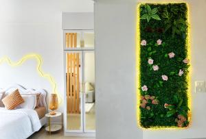a bedroom with a green wall with pink flowers at Panoramic Condo 50 sqm Karon in Karon Beach