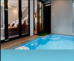 a large swimming pool in a room with a bedroom at Villa Almahyra Batu in Batu