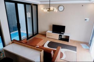 バトゥにあるVilla Almahyra Batuのソファと壁掛け時計のあるリビングルーム