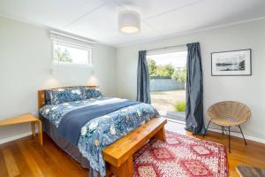 a bedroom with a bed and a window at Little Blue Bach in Martinborough 