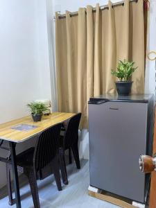 ein Tisch und ein Kühlschrank mit zwei Topfpflanzen darauf in der Unterkunft Tuyu Homestay in General Luna