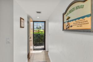 a hallway with a sign for a beach house at Prime Location I 2 Bed Setup Directly Across Street From South Beach Access in Henry Key