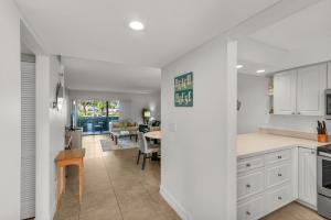 a kitchen with white cabinets and a dining room at Prime Location I 2 Bed Setup Directly Across Street From South Beach Access in Henry Key