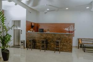 a bar in a room with stools and a bench at Lucky Transit Hotel - Katunayake Airport in Katunayaka