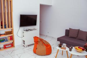 ein Wohnzimmer mit Sofa und Fernseher in der Unterkunft Cuibul Negru in Teşila