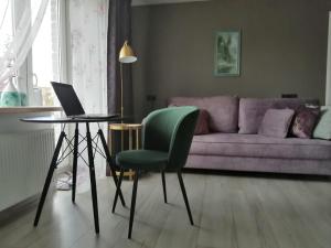 a living room with a couch and a table with a laptop at Few Steps to the Bay in Jūrmala