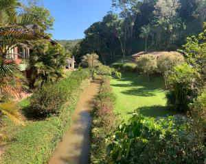 a path through a garden with trees and bushes at Casa de Campo vista para o Lago em Juquitiba SP in Juquitiba