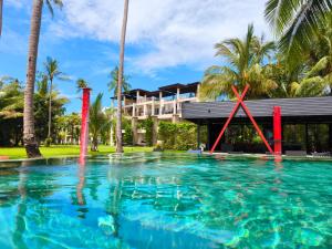une piscine devant un immeuble avec des palmiers dans l'établissement Blue Haven Bay Villa 21D and Resort Apartments, à Ko Chang
