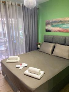 une chambre avec un grand lit et des murs verts dans l'établissement M.O.M.’s, à Alexandroúpolis