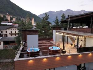 due vasche sul tetto di una casa con montagne di Hotel Ushba in Mestia a Mestia