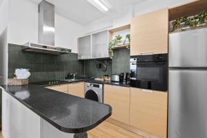a kitchen with stainless steel appliances and wooden cabinets at Lazuli Sea View Beachfront- Ap 61 in Larnaca