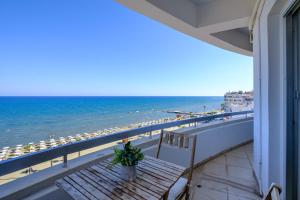 a balcony with a table and a view of the beach at Lazuli Sea View Beachfront- Ap 61 in Larnaca