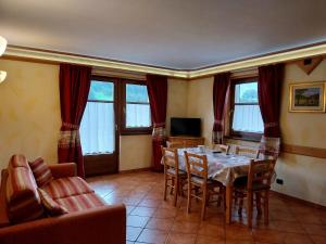 a living room with a dining room table and chairs at Residence Casa Federica in Valfurva