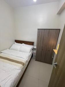 a small bedroom with a bed and a wooden cabinet at Cozy and Aesthetic Unit near to NAIA Airport Y&N Staycation in Manila