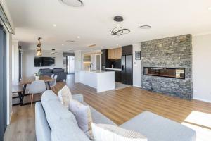 a living room with a couch and a fireplace at Stonehenge Retreat in Martinborough