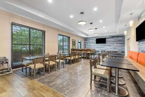 a dining room with tables and chairs and a tv at Comfort Suites in Columbia