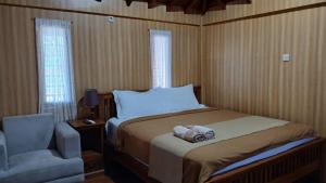a bedroom with a bed and a chair and a chair at Han's Villa in Sumbawa Besar