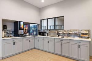 a large kitchen with white cabinets and a window at Ramada by Wyndham Bainbridge in Bainbridge