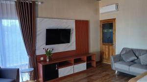 a living room with a couch and a television at Han's Villa in Sumbawa Besar
