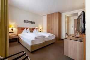 a hotel room with a bed and a television at Hotel am Jakobsmarkt in Nuremberg
