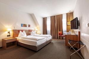 a hotel room with a bed and a desk at Hotel am Jakobsmarkt in Nuremberg