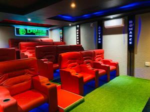 a cinema room with red chairs and a neon sign at Debreeze guest lodge in Malelane