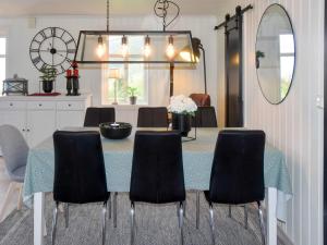 a dining room with a table with chairs and a mirror at 6 person holiday home in Åram-By Traum in Sandvik