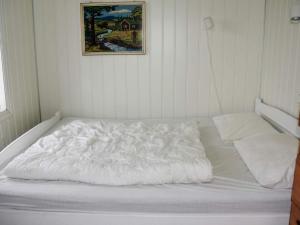 a white bed in a room with a picture on the wall at 6 person holiday home in Åram-By Traum in Sandvik