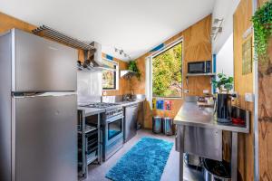 a kitchen with a stainless steel refrigerator and wooden walls at 2 minutes to town! No car needed! Compact and Warm in Queenstown +15 photos