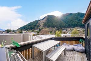 a balcony with a wooden bench and a table at 2 minutes to town! No car needed! Compact and Warm in Queenstown