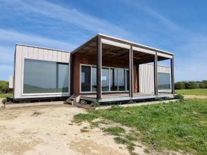 NarrawongOcean View Retreat的现代房屋,在田野上设有玻璃窗