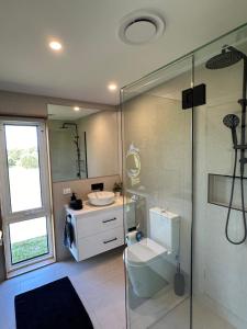 NarrawongOcean View Retreat的带玻璃淋浴和水槽的浴室