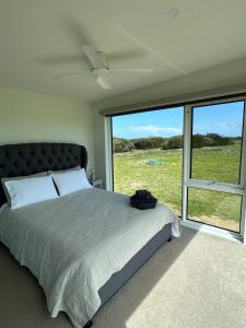 NarrawongOcean View Retreat的一间带床和大窗户的卧室
