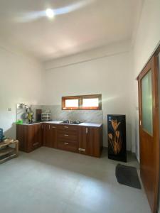 a large kitchen with wooden cabinets and a window at Cewin's Homestay in Kuta Lombok +111 photos