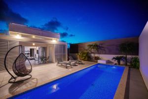 宫古岛Villa Conte的晚上有游泳池的房子